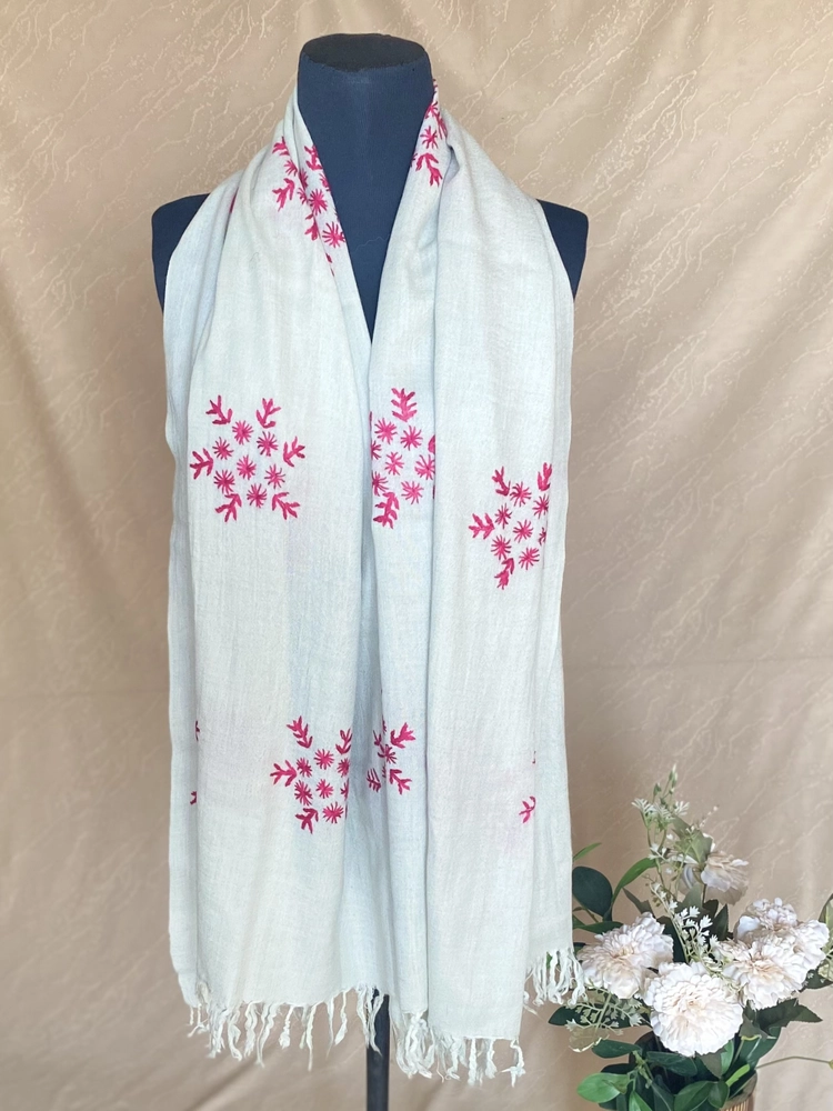 Handwoven ice blue cashmere scarf with intricate multicolored embroidery, displayed on a mannequin.