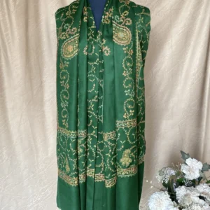 Handwoven forest green cashmere scarf with intricate multicolored embroidery, displayed on a mannequin.