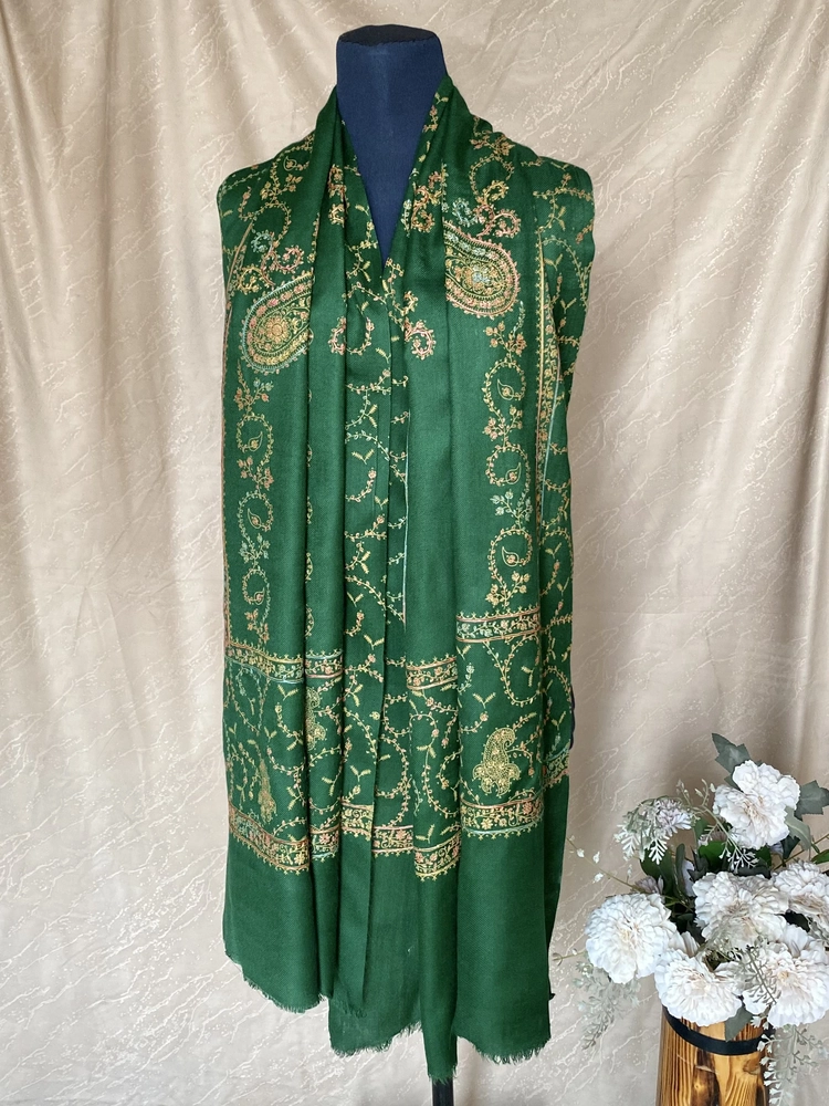 Handwoven forest green cashmere scarf with intricate multicolored embroidery, displayed on a mannequin.