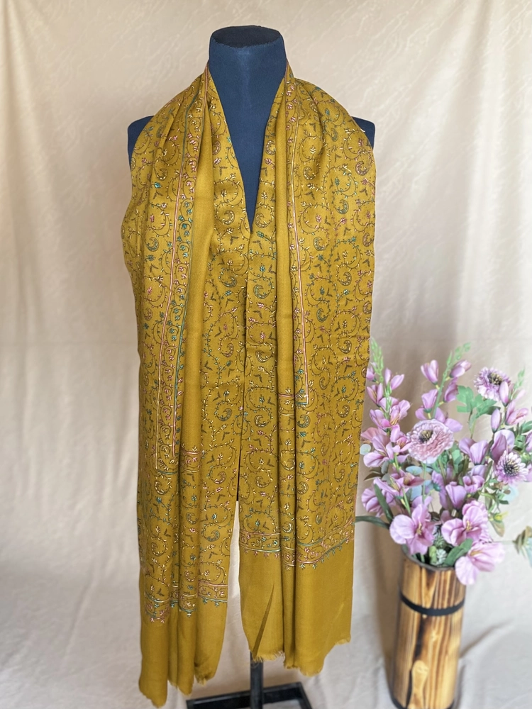 Handwoven gold cashmere scarf, displayed on a mannequin.