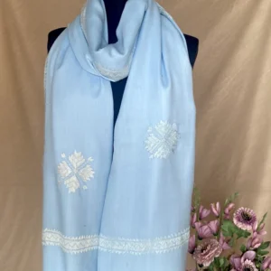 Handwoven sky blue cashmere shawl, displayed on a mannequin.