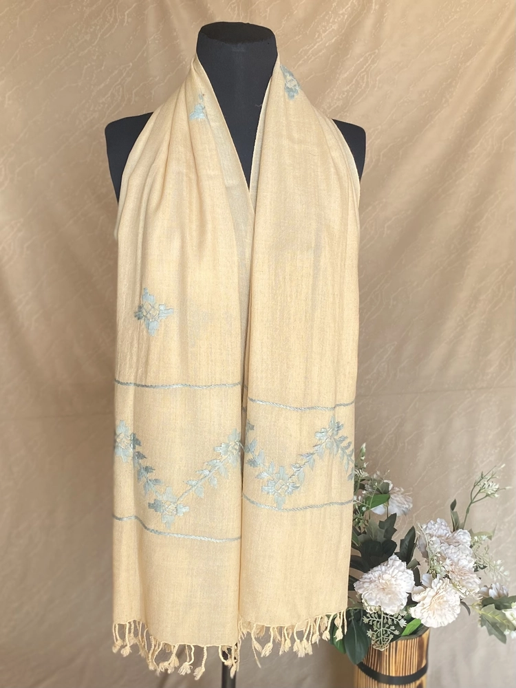 Handwoven warm cream cashmere scarf, displayed on a mannequin.